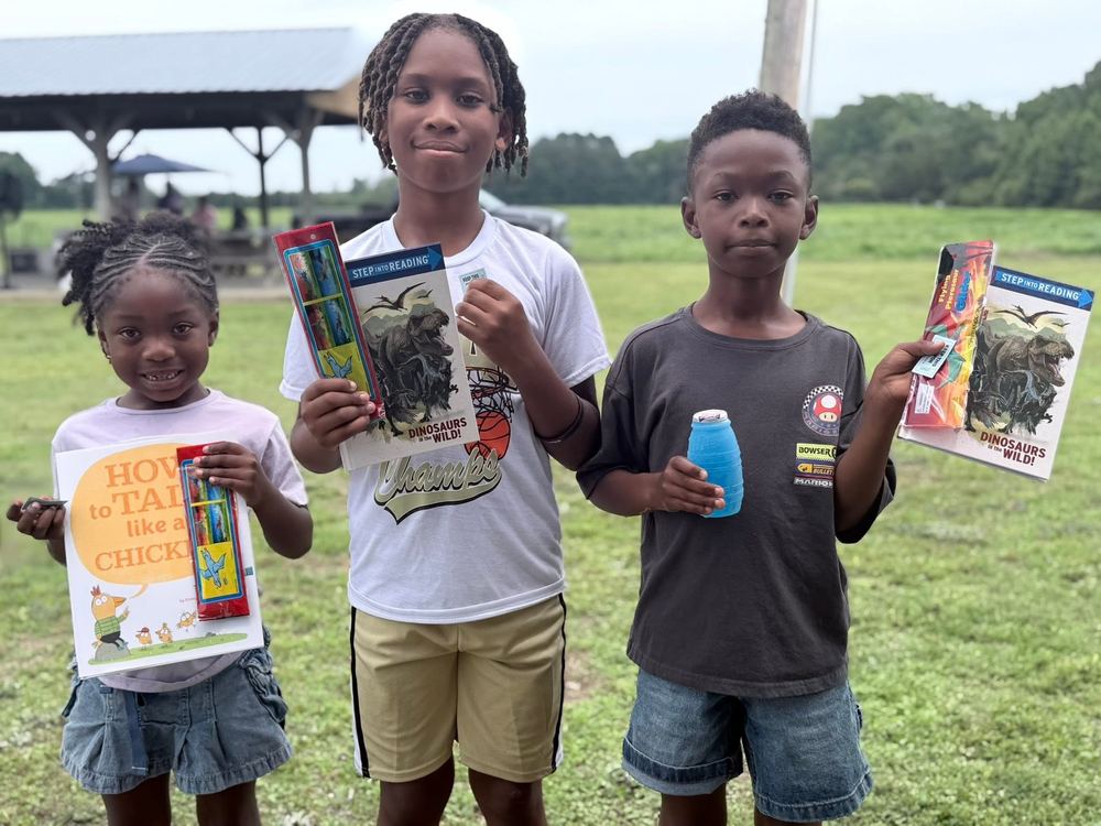 Students showing off new books at a community reading event