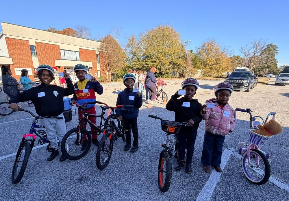 Children with new bikes and helmets at a bike safety event