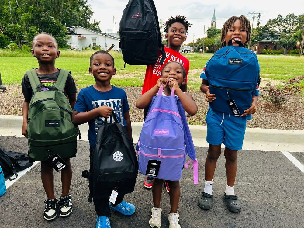 Children with new backpacks at a back-to-school giveaway